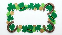 St. Patrick's Day frame with shamrocks, leprechaun hats, gold coins and horseshoes on white background for Irish holiday celebrations and decorations.
