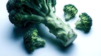 Fresh green broccoli florets arranged on clean white background, organic vegetable nutrition concept for healthy eating and cooking recipes.