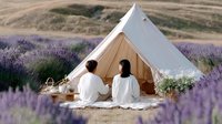 Romantic couple enjoying luxury glamping experience in lavender field with white canvas tent and picnic setup for outdoor adventure vacation.