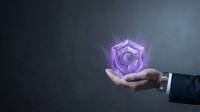 Businessman hand holding glowing purple shield with crescent moon symbol for cybersecurity protection and data privacy concepts.