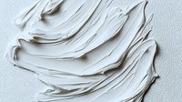 Artistic white cream texture with smooth wavy swirls and peaks creating an abstract pattern. Cosmetic product background for skincare and beauty marketing.