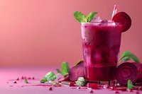 Fresh beetroot smoothie with mint leaves and ice cubes in glass on pink background, raw sliced beets and green herbs for healthy detox drink.