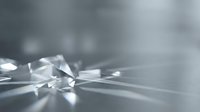 Transparent crystal shards scattered on reflective surface with soft light creating sparkle effects, suitable for luxury, jewelry, and abstract design projects.