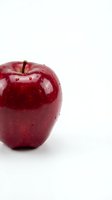 Fresh red apple with water droplets isolated on white background, ready for food and nutrition design projects.
