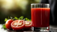 Fresh tomato juice in glass with sliced ripe tomatoes and green herbs on rustic wooden table, natural light background, healthy drink concept.