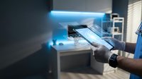 Smart home automation control using tablet device in modern kitchen with LED lighting and connected appliances for IoT technology management.