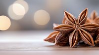 Star anise pods on wooden surface with soft bokeh lights in background, macro food photography highlighting natural texture and warm brown tones.