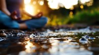 Serene meditation scene at sunset with person in lotus position by water, golden sunlight reflecting on rippling surface, creating peaceful atmosphere.