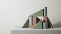 Geometric composition with cylindrical and rectangular forms in sage green, dusty rose, and metallic silver tones arranged on neutral platform for modern design projects.