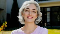 Middle-aged Caucasian woman with short silver hair smiling confidently outdoors in purple top. Professional headshot for business marketing materials.