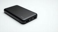 Black portable power bank with dual USB ports and LED indicators isolated on white background for electronic device charging and mobile accessories.