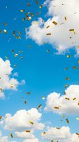 Golden confetti pieces falling from bright blue sky with fluffy white clouds creating festive celebration atmosphere for party and success concepts.