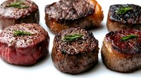 Grilled beef steaks with herbs on white background. Premium meat cuts perfectly cooked with rosemary garnish for restaurant menu and culinary projects.
