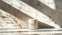 Minimalist cosmetic cream jars with pampas grass on concrete background in morning sunlight with harsh shadows. Natural skincare concept.