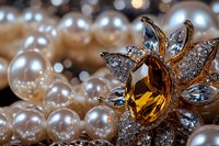 Elegant brooch with amber crystal and diamonds nestled among lustrous pearl necklace, macro jewelry photography with soft bokeh highlights in background.
