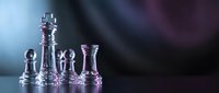 Transparent glass chess pieces on dark reflective surface with blue and purple lighting, symbolizing strategy, leadership, and competition.