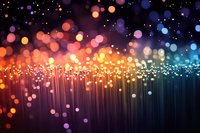 Glowing fiber optic strands emit vibrant bokeh lights in orange, pink and blue hues against dark background, creating magical illuminated abstract pattern.