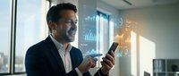 Professional businessman using smartphone with digital analytics interface displaying charts and data visualizations in modern office environment.