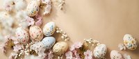 Elegant Easter eggs with golden patterns and spring blossoms on neutral background for holiday decorations and seasonal greeting cards.