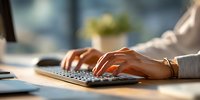 Professional woman hands typing on laptop keyboard in modern office workspace with natural sunlight for business and productivity concepts.