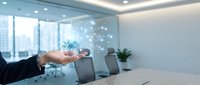 Businessman in dark suit extending hand over conference table with digital network overlay and cityscape visible through windows, representing business partnership and corporate connection.