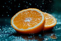 Fresh juicy orange slices with water drops on dark background, dramatic lighting and splashing water creates appetizing citrus fruit composition.