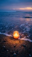 Glowing candle in glass jar on sandy beach at twilight with gentle waves and colorful sunset sky creating peaceful romantic atmosphere for meditation and relaxation.