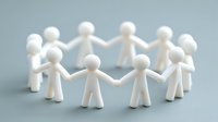 White figurines forming circle with joined hands on blue background, symbolizing unity, teamwork, and community support for business concepts.