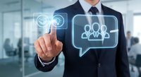 Professional businessman in dark suit touching digital interface with team management icons in modern office environment for corporate communication solutions.