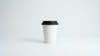 White disposable coffee cup with black lid isolated on clean background for branding mockup and cafe marketing materials.