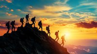 Silhouettes of hikers climbing rocky mountain peak at dramatic sunset. Group adventure journey, leadership concept showing team reaching summit together.