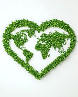 Green leaves forming heart-shaped world map on white background, environmental concept for eco-friendly and sustainable global initiatives.