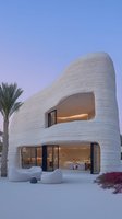 Modern curved architecture with organic flowing lines showcases innovative desert villa design featuring rammed earth walls, panoramic windows, and minimalist outdoor seating at dusk.