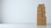 Stacked cardboard boxes arranged in tower formation on white surface, representing shipping, logistics, storage, and delivery concepts for business applications.
