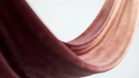 Abstract flowing fabric waves in burgundy and rose gold creating elegant curves and shadows on white background for luxury design projects.