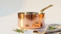 Copper saucepan with brass handle on marble surface, professional kitchen cookware for gourmet cooking and culinary preparation.