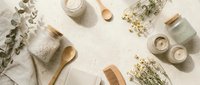 Spa and wellness products arranged flat lay with natural ingredients, wooden accessories, dried herbs, and skincare jars on neutral background for beauty and relaxation themes.