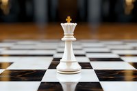 White king chess piece standing alone on checkered board with dramatic lighting and shallow depth of field, symbolizing leadership and strategy in business.