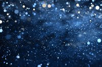 Magical blue glitter background with sparkling bokeh lights and defocused particles creating dreamy atmosphere for festive designs and holiday decorations.
