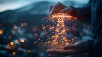 Glowing electric power transmission tower with digital network connections floating between hands against blurred city lights background at dusk.