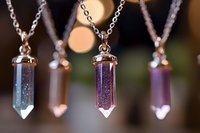 Elegant crystal pendant necklaces with metallic chains displayed against dark background. Luxury jewelry accessories for fashion and style.