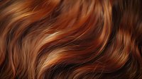 Flowing auburn hair with golden highlights showcasing natural waves and rich copper tones for beauty and haircare concepts.