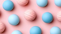 Pastel blue and pink spheres with striped pattern on soft pink background creating minimalist geometric composition for modern design and decoration.