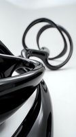 Abstract black glossy sculptural forms with flowing curves and reflective surfaces creating modern artistic composition for contemporary design projects.