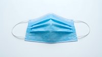Blue surgical face mask with elastic ear loops isolated on white background, ready for healthcare, medical, and safety design applications.