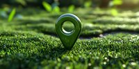 Green location pin marker on moss covered ground with natural sunlight and bokeh effect, representing eco-friendly navigation and sustainable travel concepts.