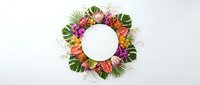 Tropical floral wreath with exotic flowers and palm leaves arranged in circle on white background for summer decoration and design projects.