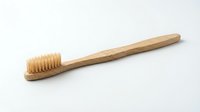 Eco-friendly bamboo toothbrush with natural bristles isolated on white background for sustainable dental care and zero waste lifestyle products.