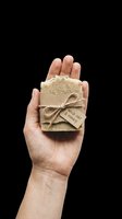 Hand holding natural handmade soap bar with twine bow and kraft tag, isolated on transparent background. Great for wellness, organic skincare, stickers, and print on demand designs.