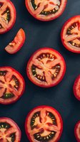 Fresh red tomato slices arranged on dark background showing juicy inner texture and seeds. Natural organic produce photography for food and cooking concepts.